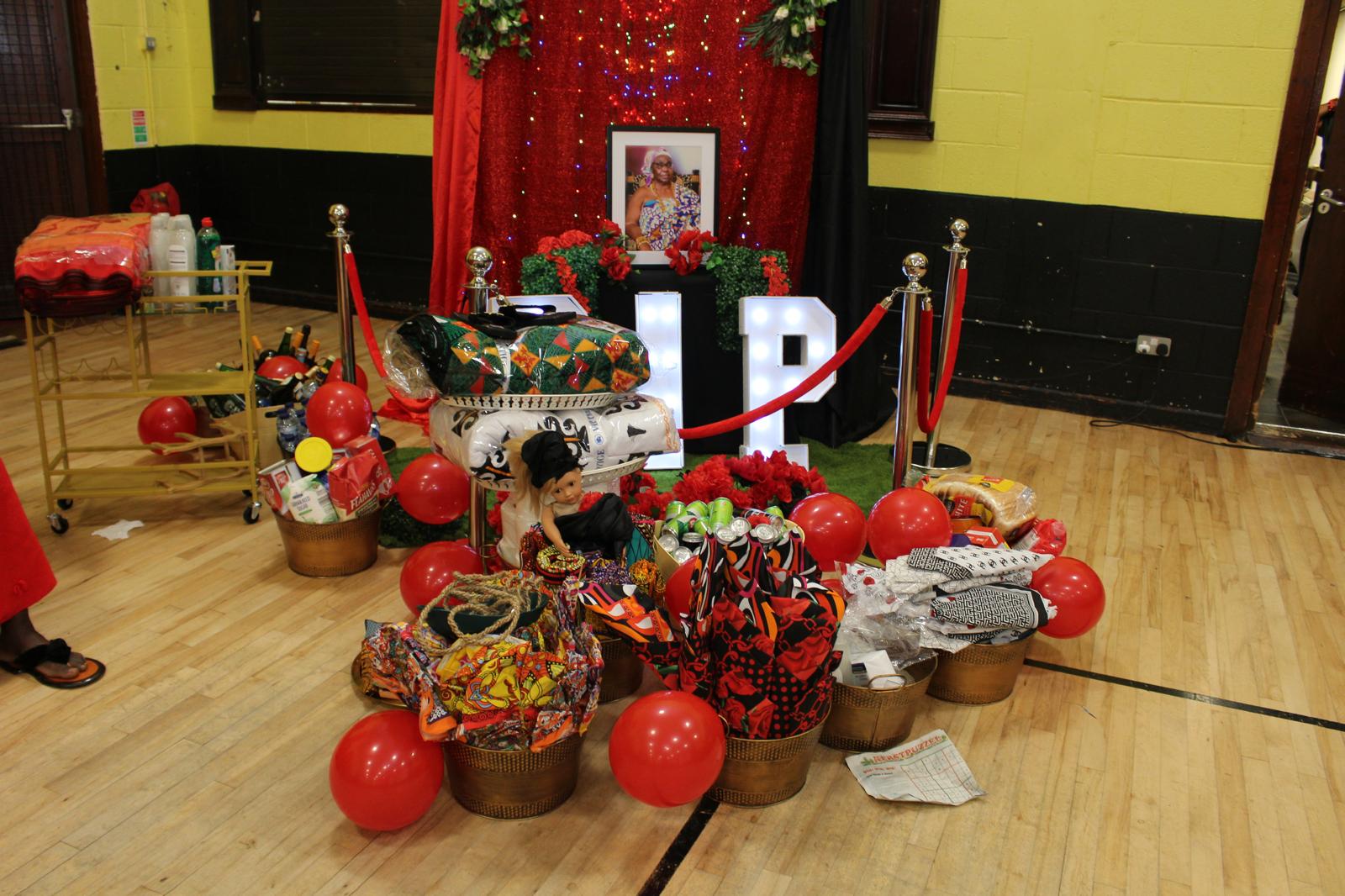 An Oheneba cultural event display with Ghanaian fabrics, gifts and red decorations